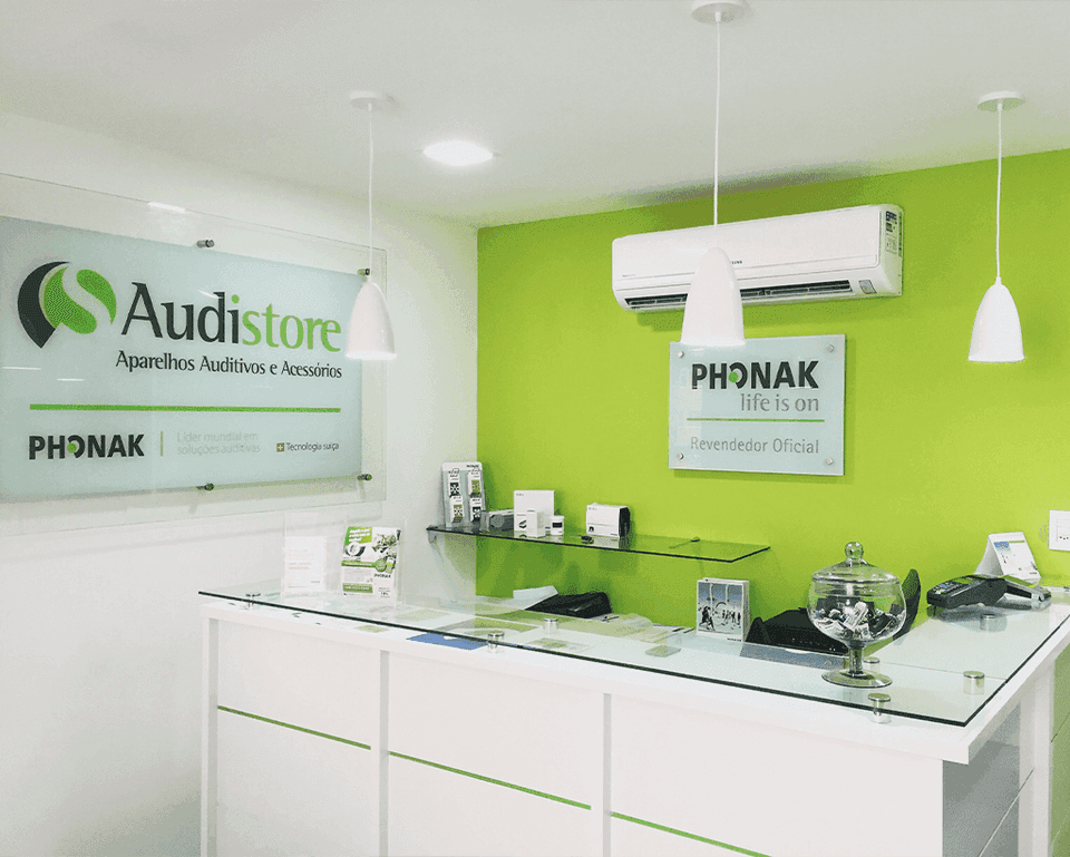 Recepção da loja Audistore, com balcão e parede verde
